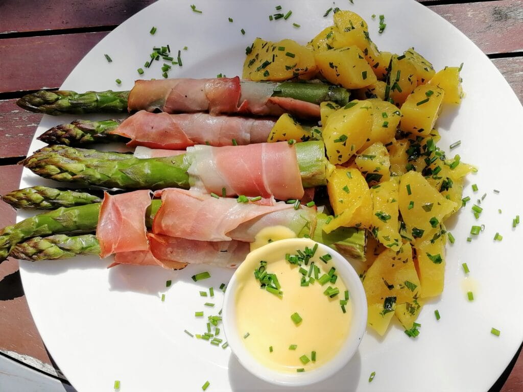 asparagus wrapped in bacon served with a hollandaise sauce