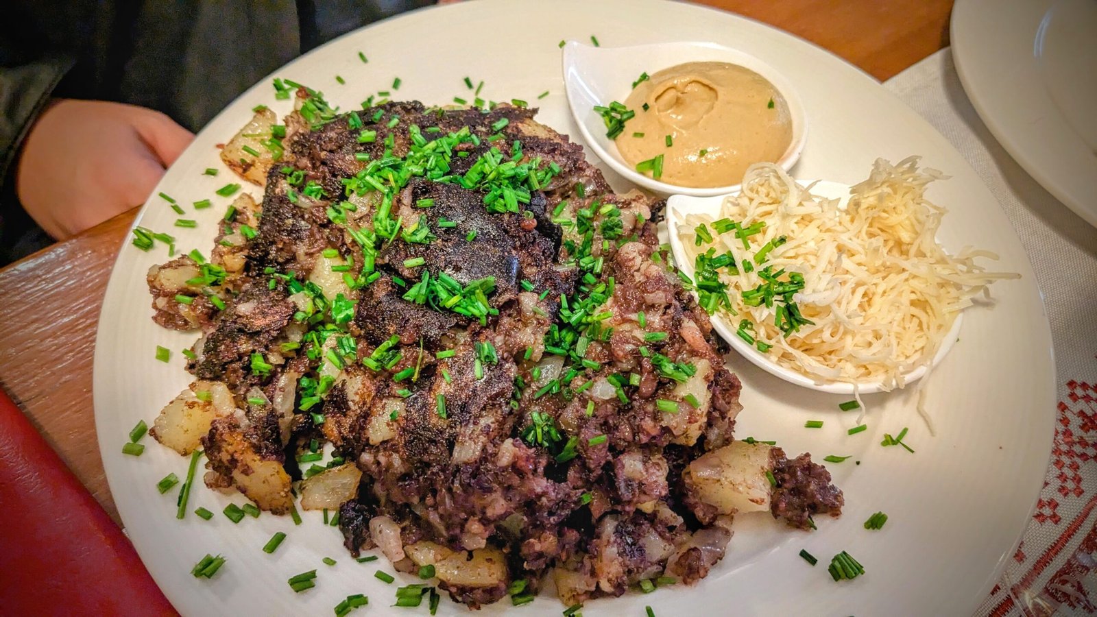 a plate of blunzngröstl with shredded horseradish and mustard