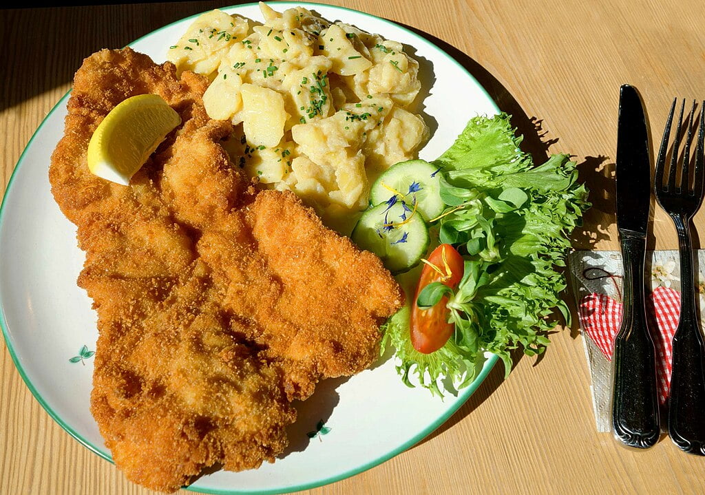 wiener schnitzel with potato salad and lettuce on a plate