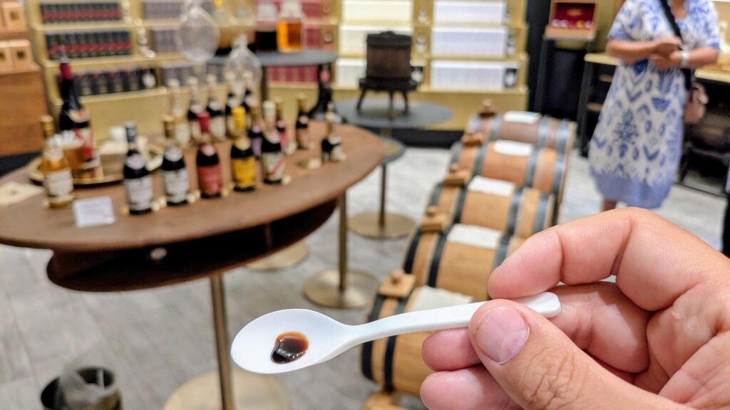 a small spoon with balsamic vinegar on it during a tasting in bologna