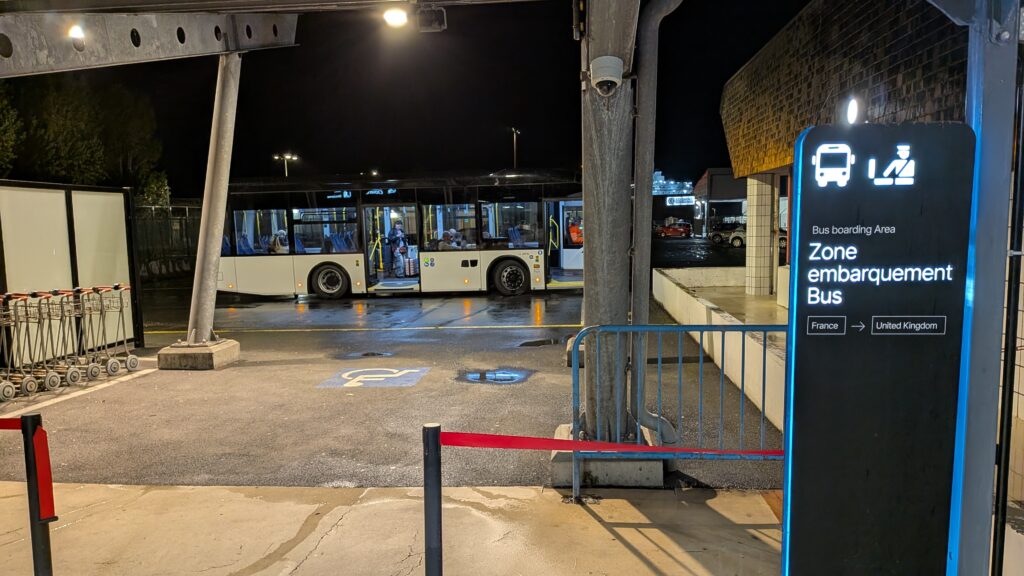 a bus taking passengers from caen ferry port check to the passenger footbridge