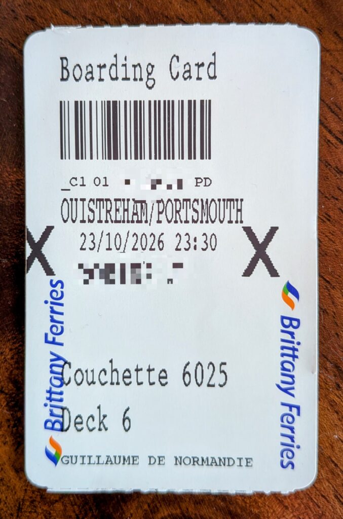 a close up photo of a brittany ferries boarding card lying on a wooden table